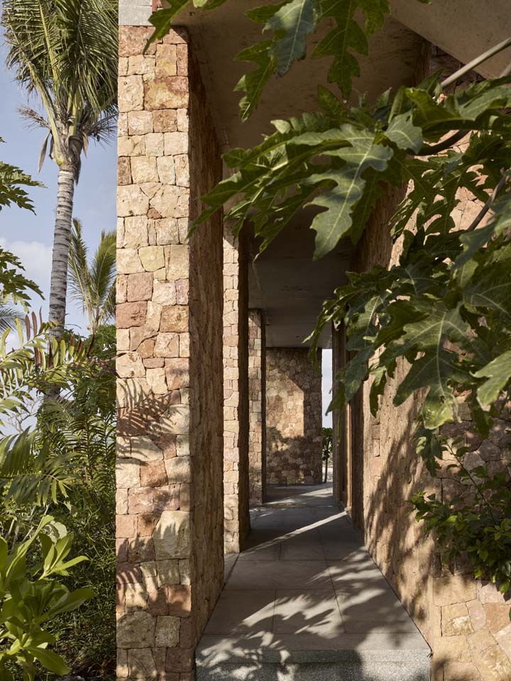 a first-floor terrace with a coral-stone wall